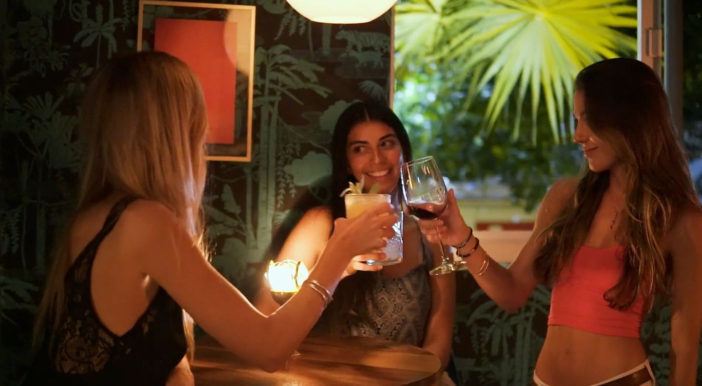 Three guests toasting with a cocktail and wine at Minibar.